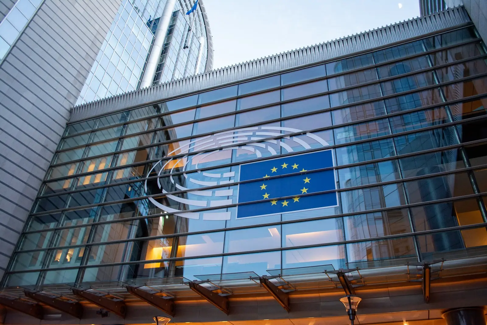 Απαγόρευση θερμικών κινητήρων: Γερμανία και Γαλλία Σημαία της Ευρωπαϊκής Ένωσης αντανακλάται σε γυάλινη πρόσοψη κτιρίου στις Βρυξέλλες
