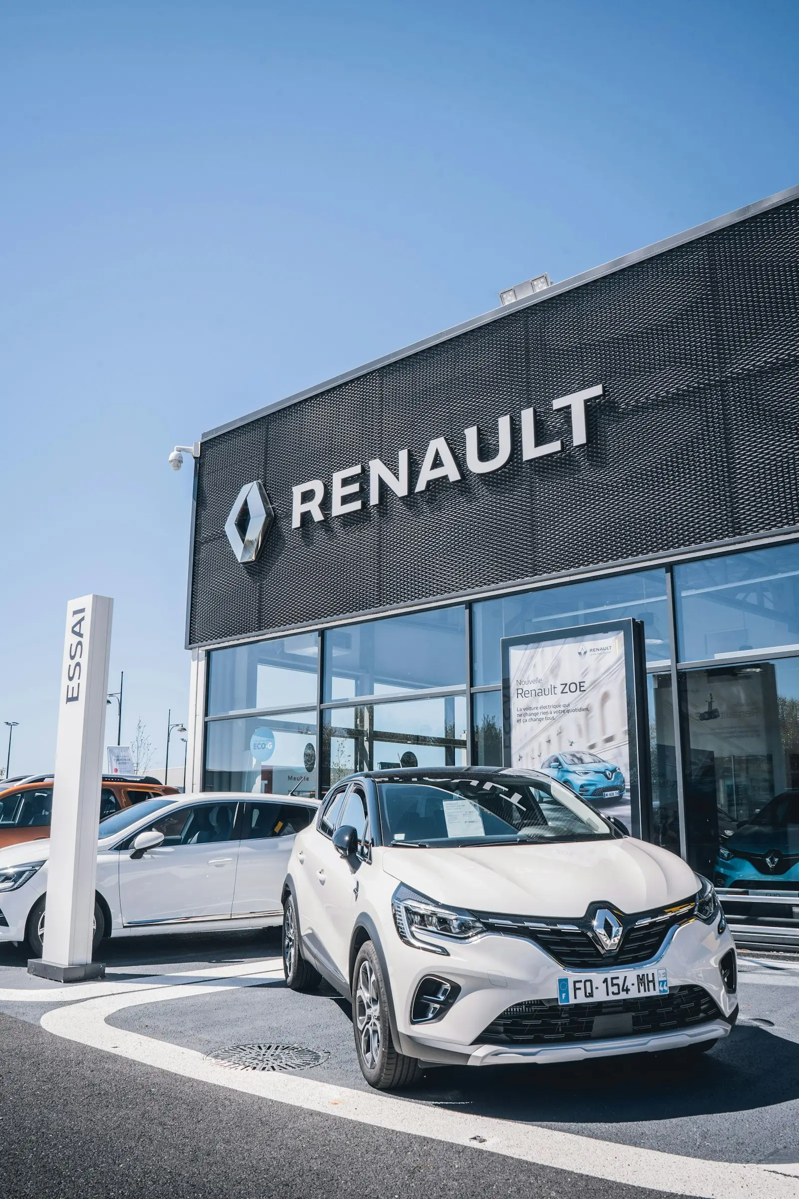 Renault 4 E-Tech: Νέα τιμή από 27.690 € Λευκό αυτοκίνητο μπροστά από αντιπροσωπεία